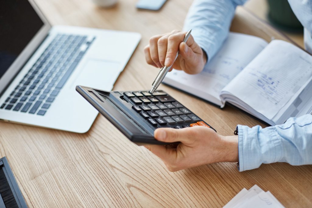 Empresário utiliza uma calculadora para verificar quanto custa para registrar uma marca